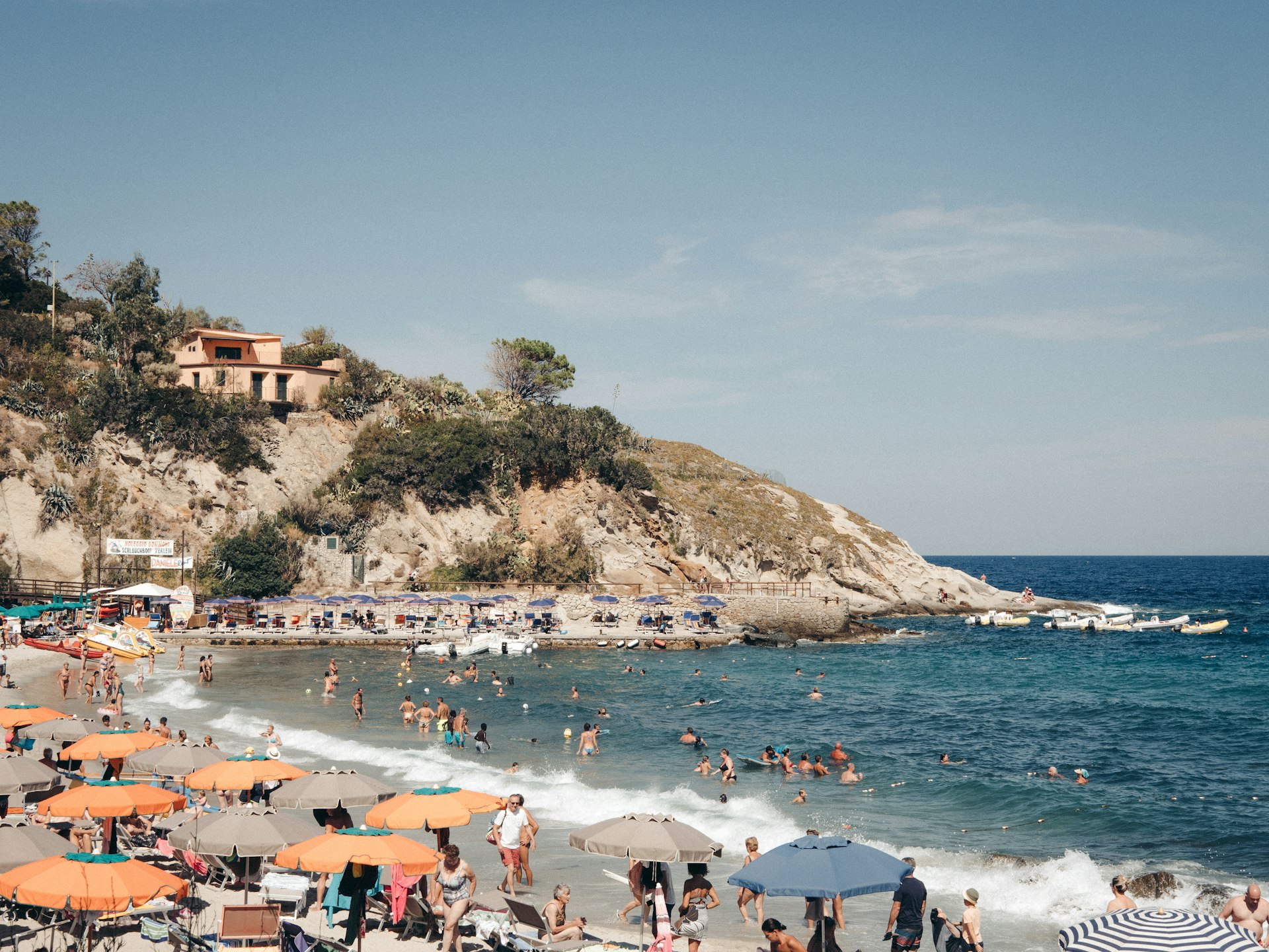 a crowded beach with lots of people and umbrellas